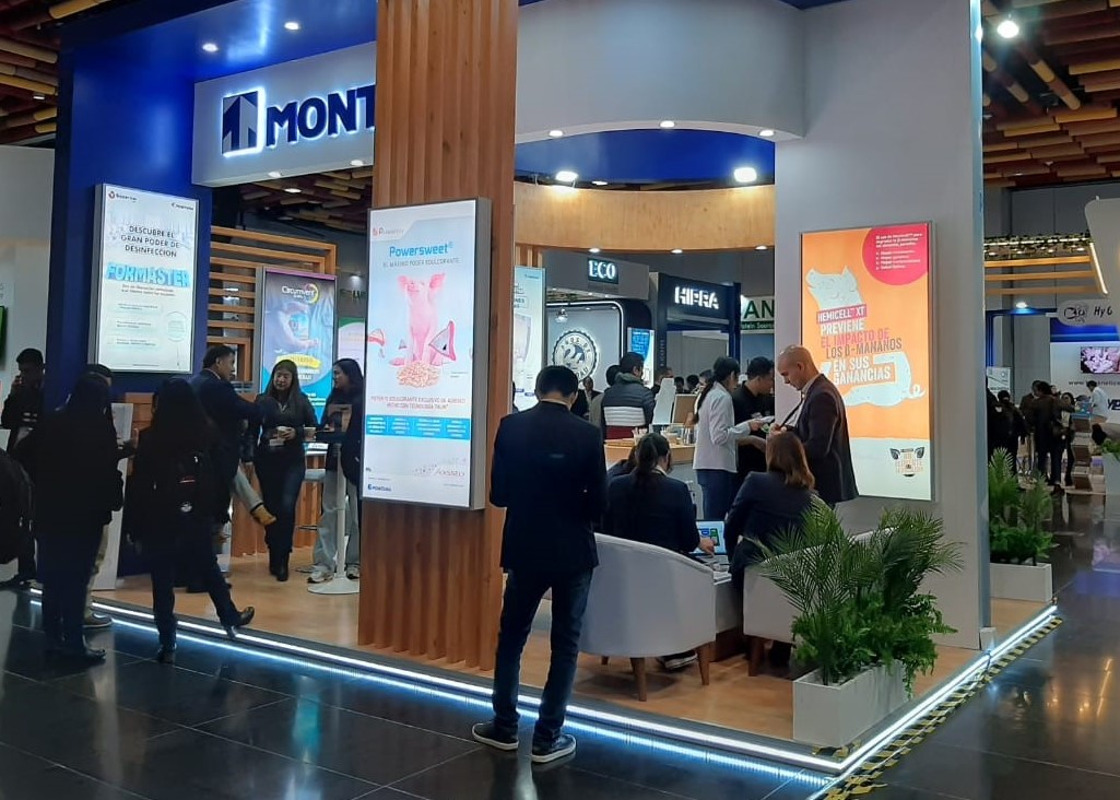 Equipo comercial atendiendo visitantes en un stand de feria profesional.